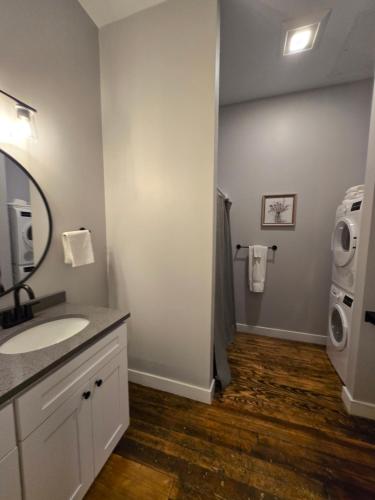 a bathroom with a sink and a washing machine at Historic Federal Hill 1Br Loft apt with onsite Gym and Barbershop in Providence