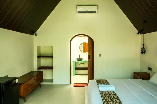 a bedroom with a bed and a dresser at Asem Bungalows in Kuta Lombok
