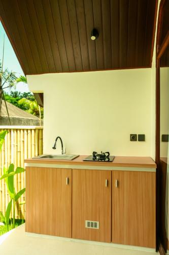 a kitchen with wooden cabinets and a sink at Asem Bungalows in Kuta Lombok