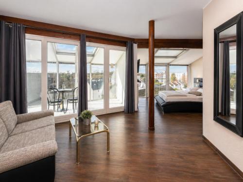 a living room with a couch and a table at Turmhotel Rhein-Main - klimatisierte Apartments in Dreieich