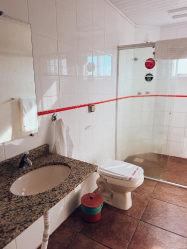 a bathroom with a toilet and a sink at Arpini Hotel in Rio Grande