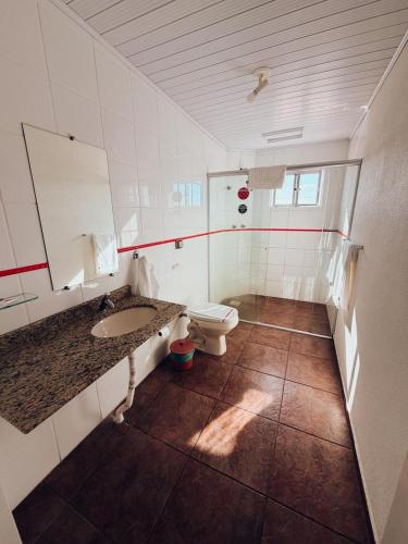 a bathroom with a toilet and a sink at Arpini Hotel in Rio Grande
