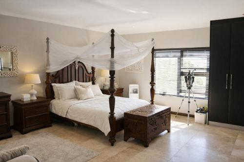 a bedroom with a large bed with a canopy at Villa on Ibis in Cape Town