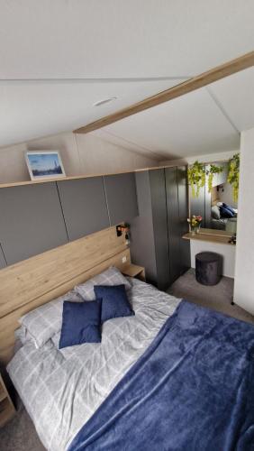 a bedroom with a large bed with two blue pillows at Devon holiday in Goodrington
