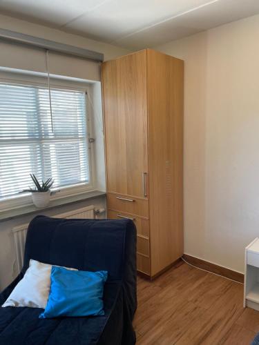 ein Wohnzimmer mit einem blauen Sofa und einem Schrank in der Unterkunft Martens studio in Malmö