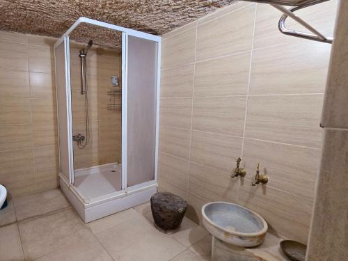 a bathroom with a shower and a toilet and a sink at Uchisar Cave House in Uçhisar