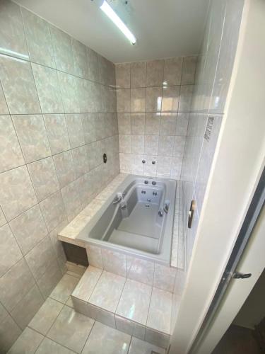 a bathroom with a tub in the corner of a room at Abaeté Palace Hotel in Abaeté