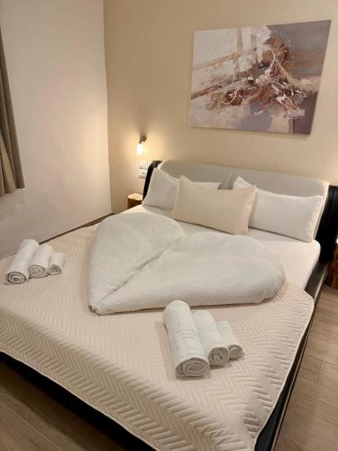 a large white bed with towels on top of it at Villetta Moscal- Buon Gusto in Affi
