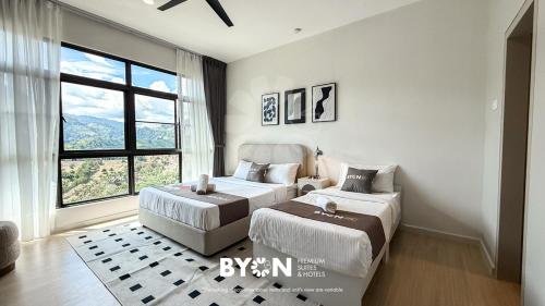 a bedroom with two beds and a window at Enclave Nature Suites Bukit Tinggi by BYON in Bentong