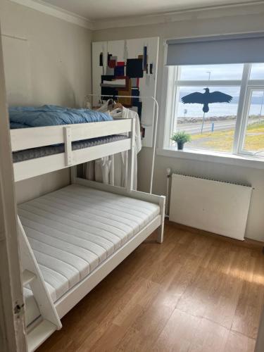 a bedroom with two bunk beds and a window at Summerhouse by the ocean in Drangsnes