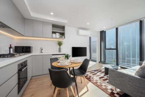 a kitchen and living room with a table and chairs at LaneStay - 2BR Panoramic Views w Pool Spa & Gym in Melbourne