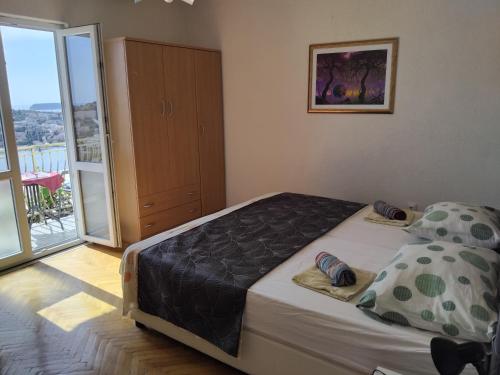 a bedroom with a large bed and a balcony at Pansion Panorama Dubrovnik's Most Beatiful Sea View in Dubrovnik