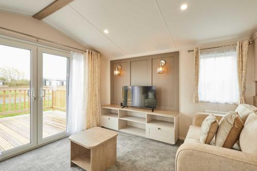 a living room with a couch and a tv at Host & Stay - Stag Lodge in Pickering