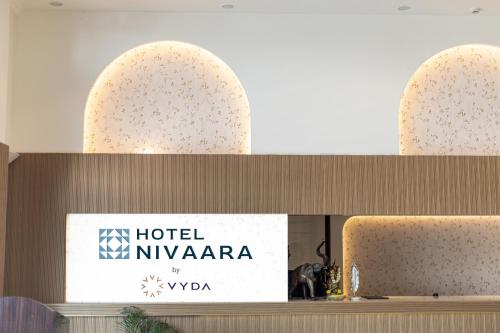 a hotel nyrkanara sign on the wall of a building at Hotel Nivaara By VYDA in Tirupati