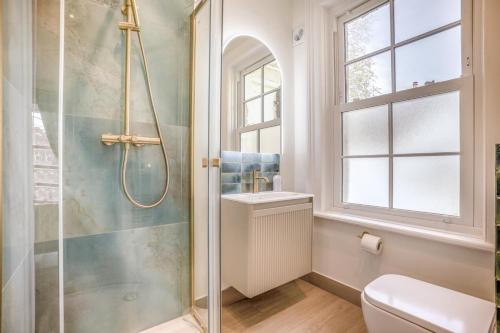 a bathroom with a shower and a toilet and a window at 4 Bed in Lyndhurst oc-nfl57 in Lyndhurst
