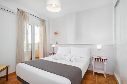 a white bedroom with a large bed and a window at Atlantico Atico PLUS by Ĥ - Playa Punta del Moral PAHT76P102 in Isla del Moral