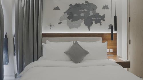 Ein Schlafzimmer mit einem weißen Bett und einer Weltkarte an der Wand in der Unterkunft Alpirious Hotel in Islamabad