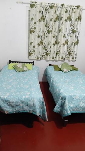 a bedroom with two beds and a window with curtains at Misty Moutain view in Pīrmed