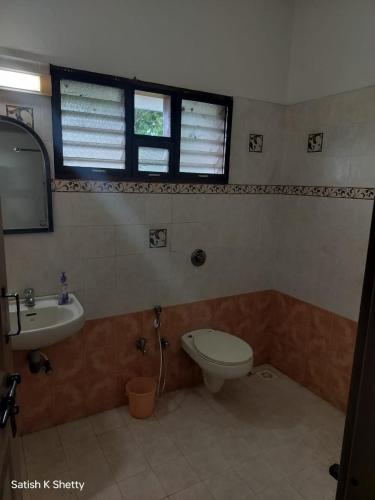 a bathroom with a toilet and a sink at Rajmata Nivas in Kaup