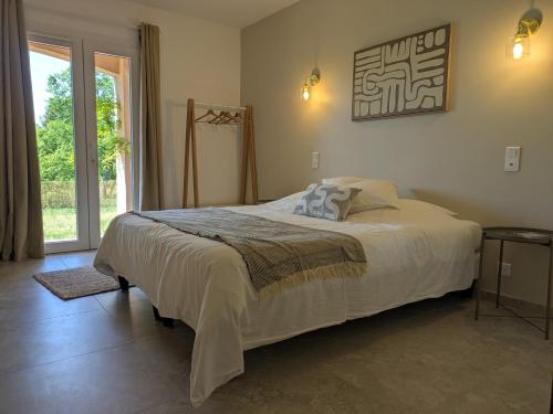 a bedroom with a bed and a large window at Villa Salesiae in Les Salles-sur-Verdon