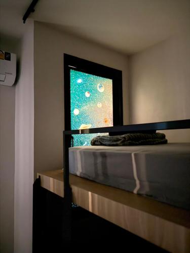 a bedroom with a bed and a window at Jupiter Hostel in Ban Khlong Haeng