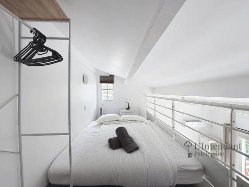 a white bedroom with a large white bed in it at Spacieux triplex avec vue mer, proche de Monaco, 54 m2 in Cap d'Ail