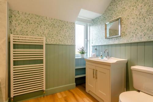 a bathroom with a sink and a toilet and a window at 3 Bed in Dingwall oc-m39032 in Dingwall