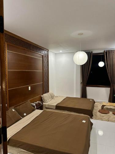 a bedroom with two beds and a large headboard at Lita Homestay in Thôn Trường Giang