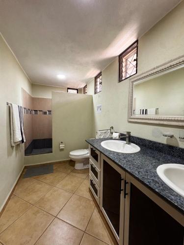 a bathroom with a sink and a toilet and a mirror at CASA Angelo in Sosúa
