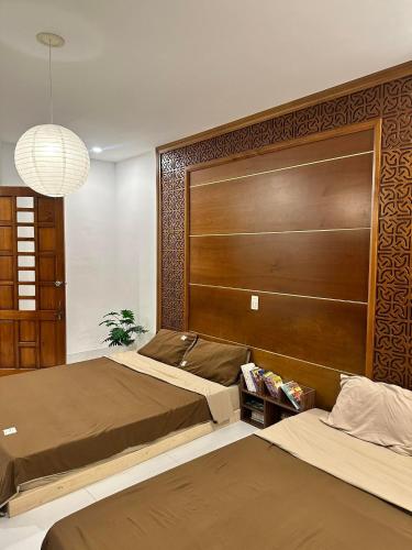 a bedroom with two beds and a large headboard at Lita Homestay in Thôn Trường Giang