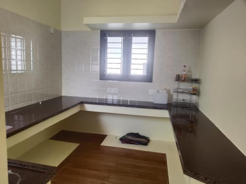 a kitchen with a sink and a window at Raja Accommodation in Kovilpatti