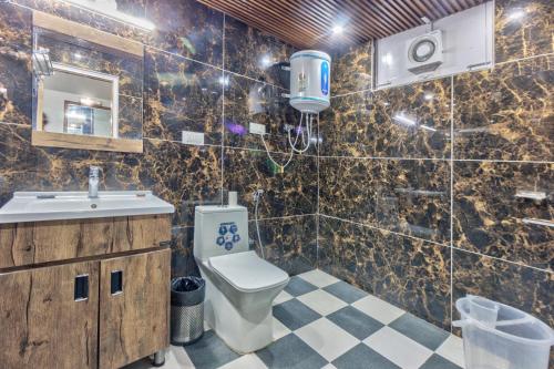 a bathroom with a toilet and a sink at Hotel Naveen Manali in Manāli