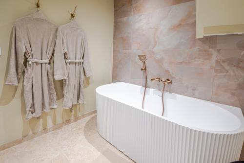 a bathroom with a bath tub and some clothes at Escale victorienne in Saint-Étienne