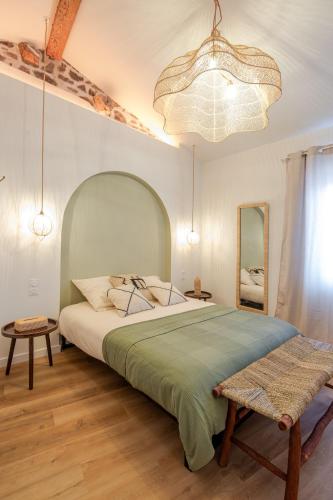 a bedroom with a large bed and a large chandelier at Escale victorienne in Saint-Étienne
