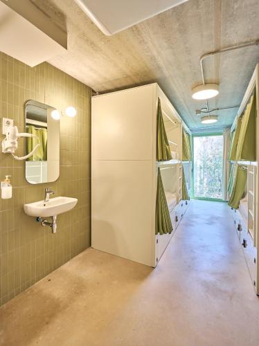 a bathroom with a sink and a mirror at Hostelfly Fira Barcelona in Hospitalet de Llobregat