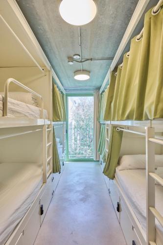 a room with bunk beds and a window at Hostelfly Fira Barcelona in Hospitalet de Llobregat