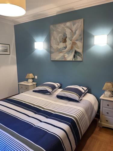 a bedroom with a large bed with blue walls at Chambres d'hôtes les Boulommiers in Samois-sur-Seine