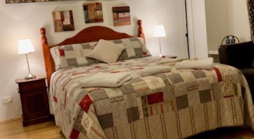 a bedroom with a bed with a quilt on it at Deluxe Queen Room in Perth