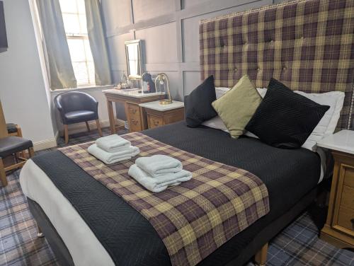 a bedroom with a bed with towels on it at Royal Dunkeld Hotel in Dunkeld