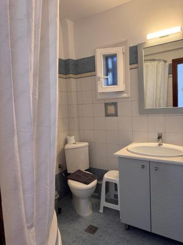 a bathroom with a toilet and a sink and a mirror at SeaBreeze Milos in Mytakas