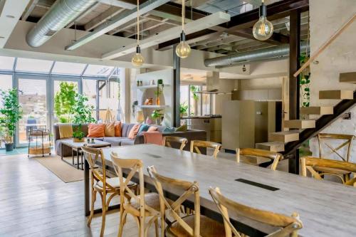 an open living room with a large wooden table and chairs at City Loft I Fireplace I Free Parking I Garden Bath in Nieuwpoort