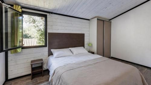 a bedroom with a large bed and a window at L'Oasis provençale - Joli chalet avec terrasse in Solliès-Toucas