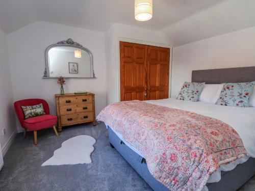 a bedroom with a large bed and a red chair at Mill View in York