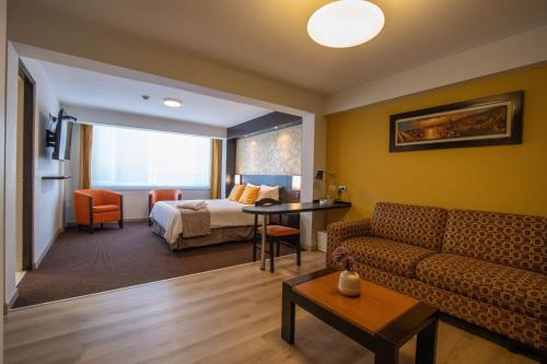 a living room with a couch and a bed in a room at Hotel Britania Miraflores in Lima