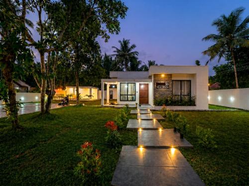 a house with a row of lights in the yard at Villa Grazia 99 in Katuneriya