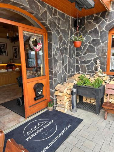 a entrance to a restaurant with a stone wall at Penzión Patrik in Ždiar