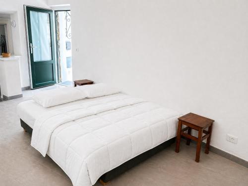 a white bedroom with a bed and a table at Casa Leonardo in Casamicciola Terme