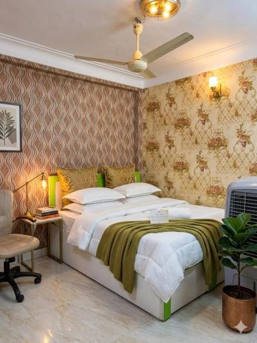 a bedroom with a large bed and a chair at Narmada Gest House in Indore