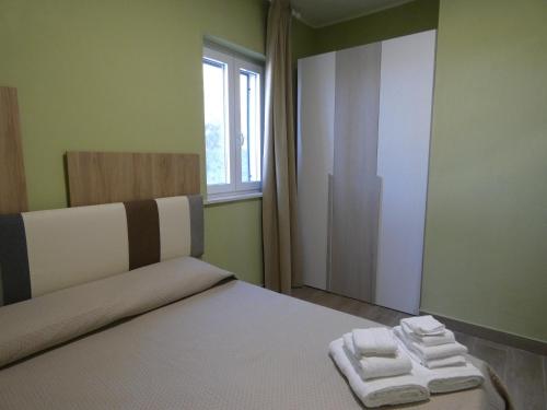 a bedroom with a bed with two towels on it at Le Dune del Gargano in Zapponeta