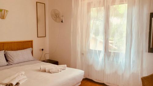 a bedroom with a bed with white sheets and a window at Vacanza nella Natura in Punta Ala